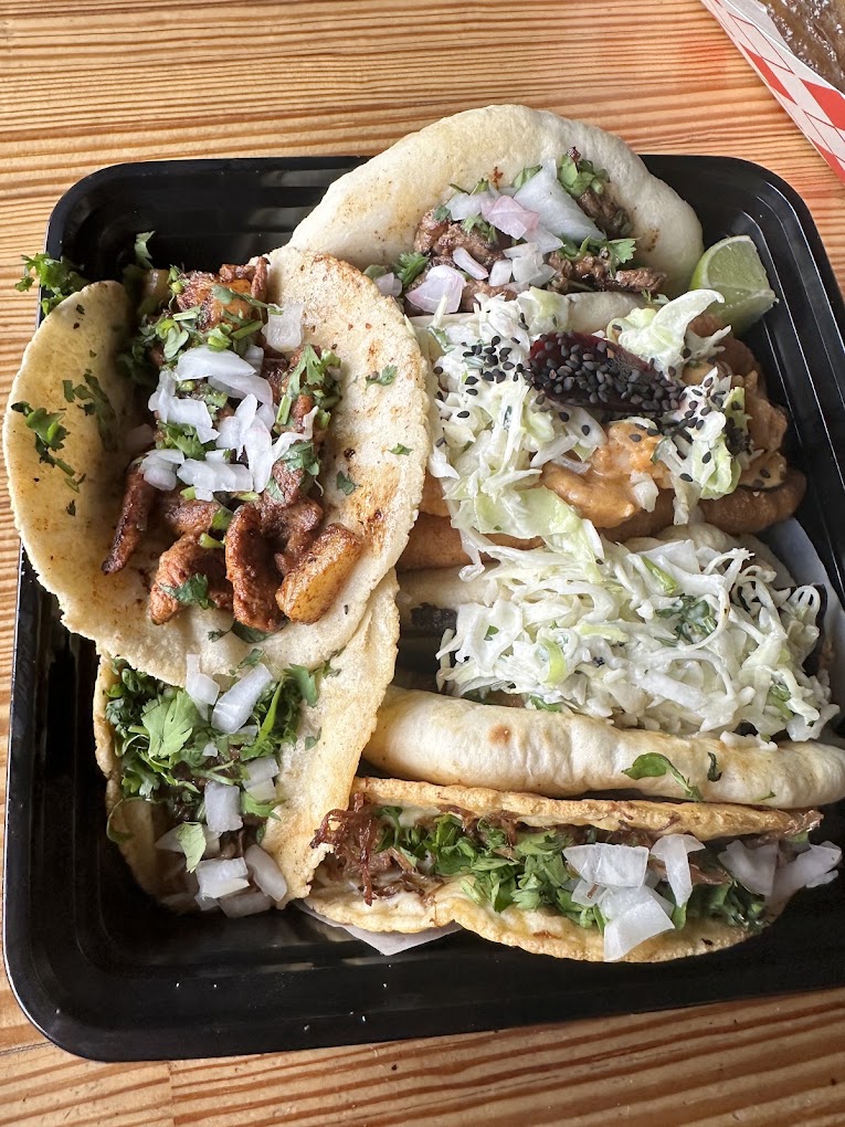 Tray of assorted tacos with handmade tortillas, slaw and lime