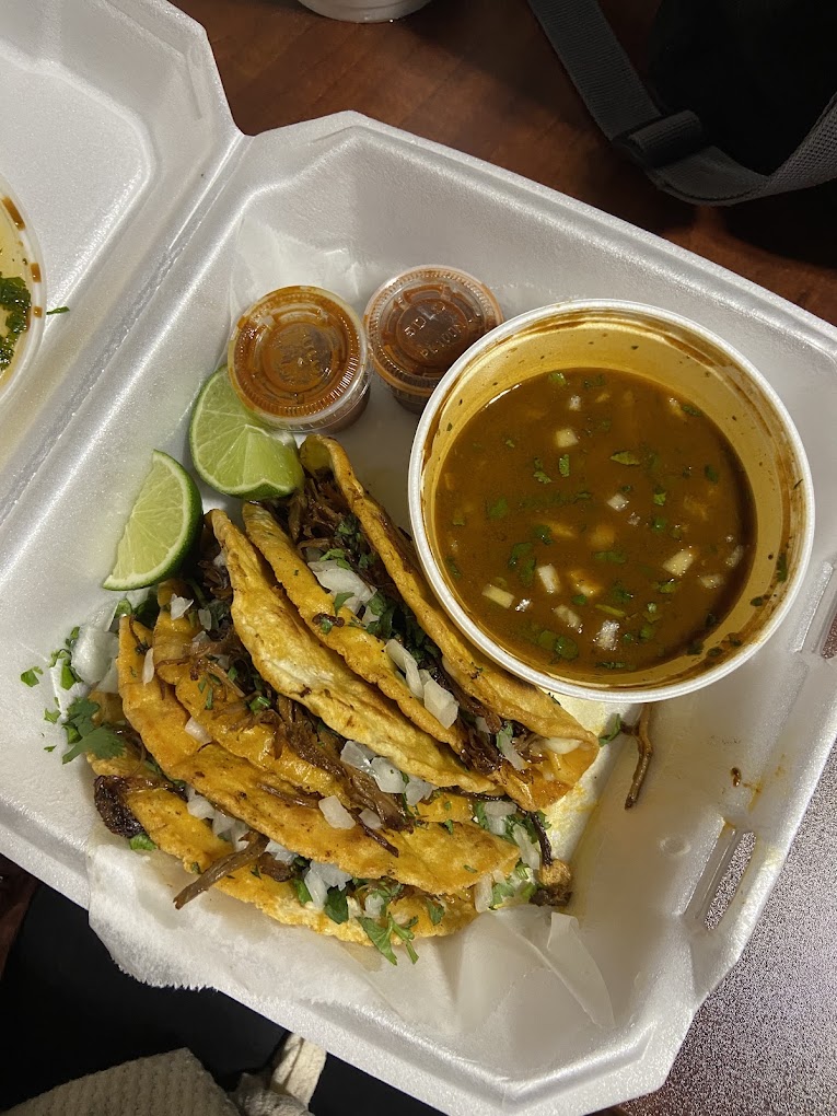 Quesabirria tacos with lime and a cup of consomé