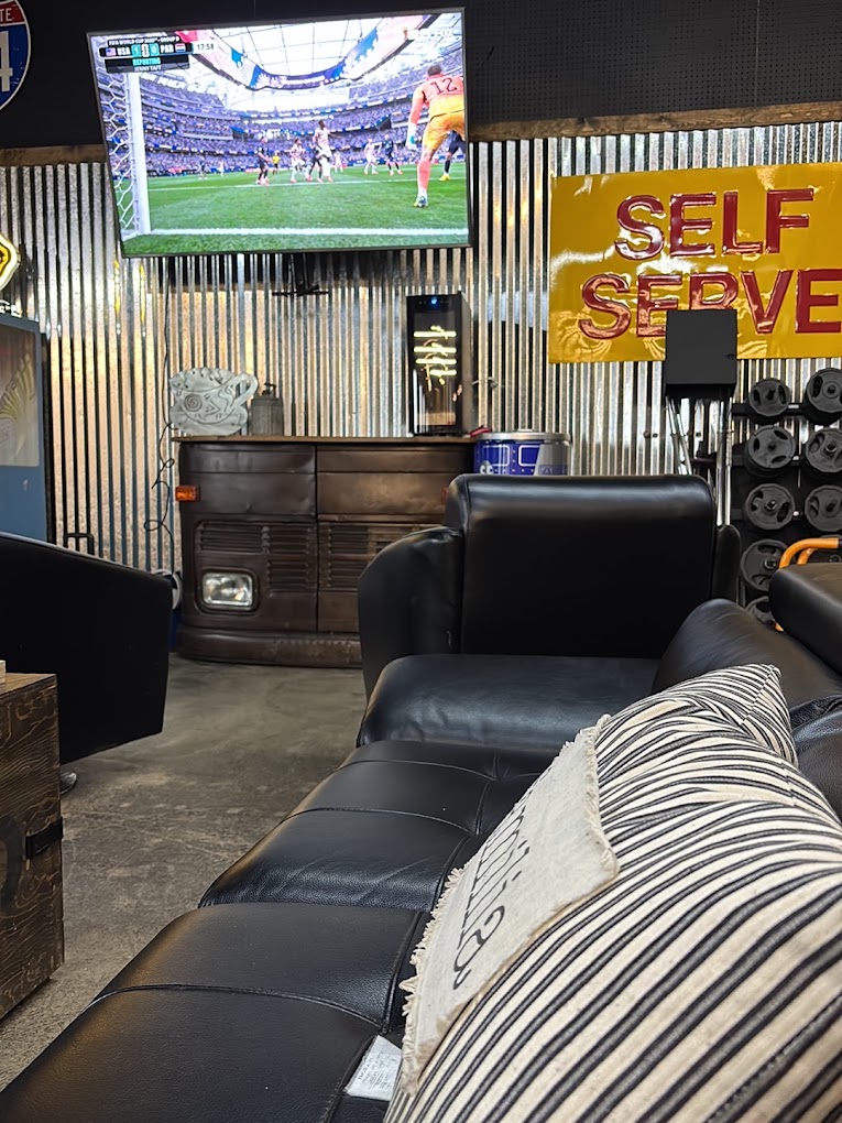 Indoor seating area with leather couches and a big screen TV